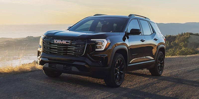2026 GMC Terrain driving on a scenic highway near Garden City Park NY with powerful turbocharged performance and AWD capability